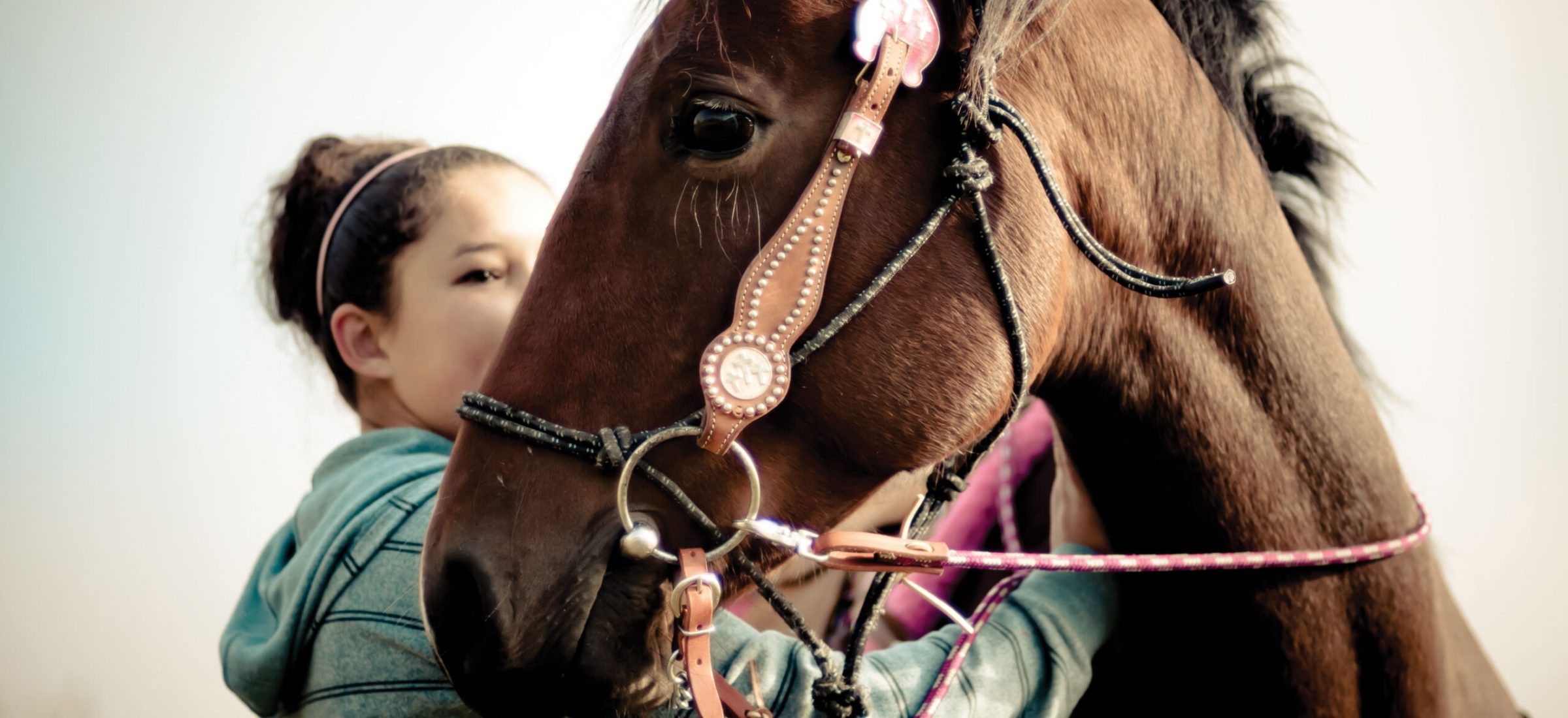 A woman standing next to a brown horse